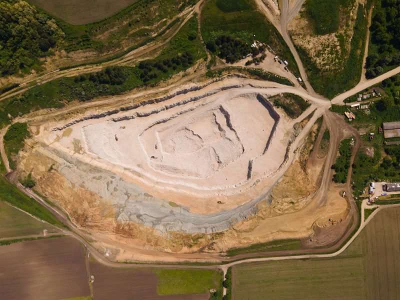Aerial view industrial of opencast mining quarry with lots of machinery at work view from above.