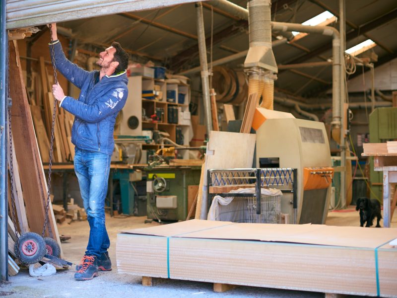 Carpenter Opening Door To Woodwork Business Premises At Start Of Working Day